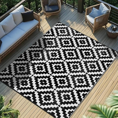Black and white patterned Favoyard outdoor rug on a wooden deck